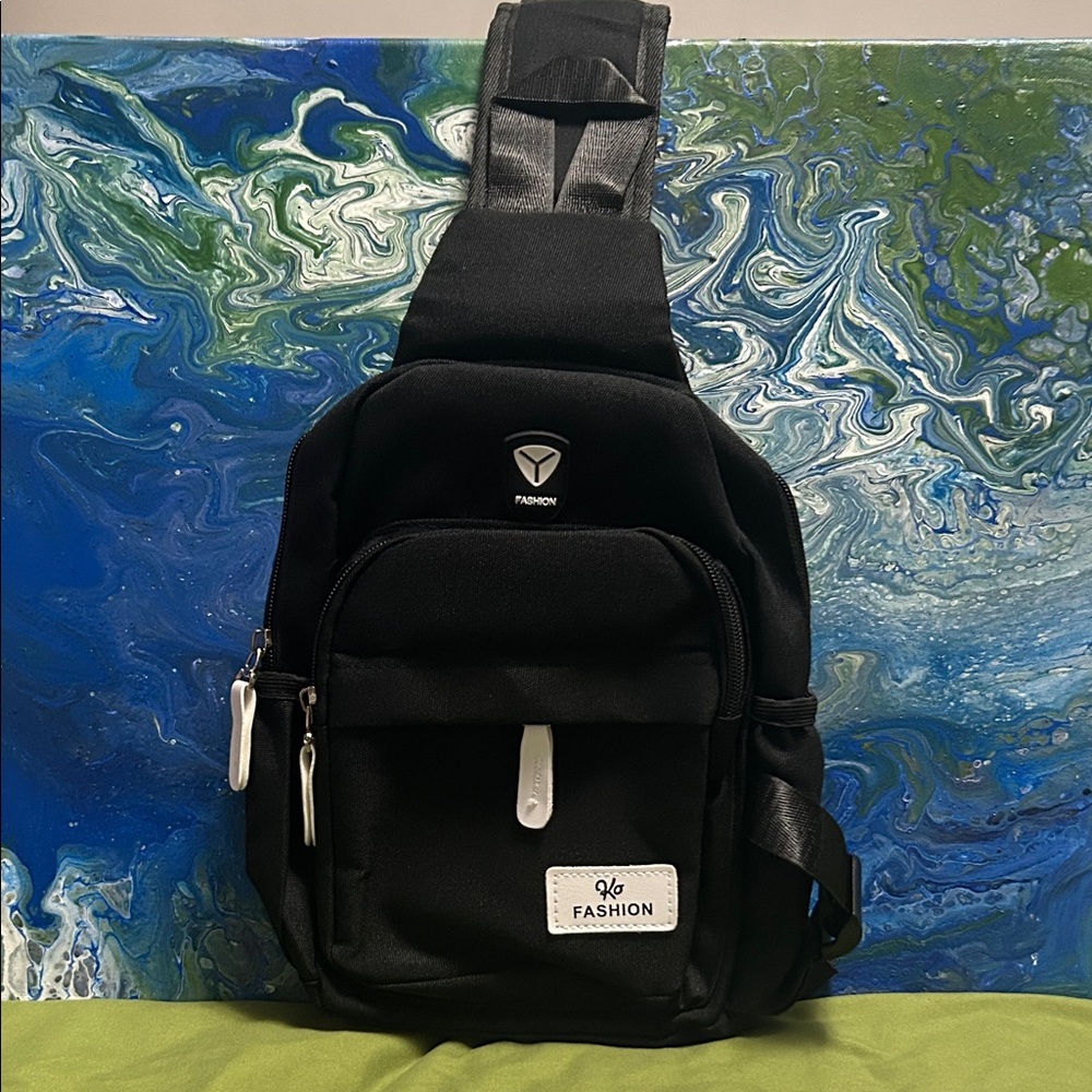 Black nylon sling bag or crossbody bag with "Fashion" text on a white label